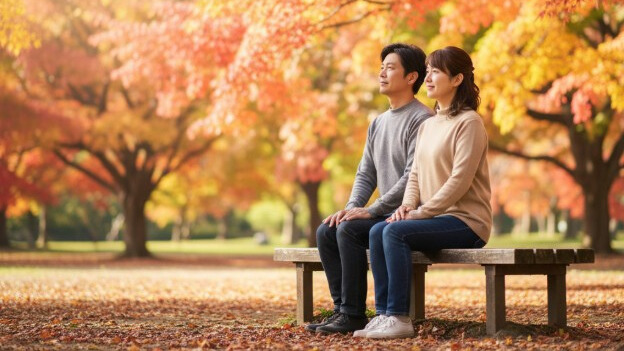 怪我の不安なく、公園で穏やかな秋の午後を過ごす夫婦。