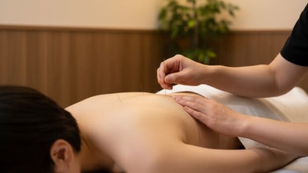 起立性調節障害の体調管理として、背中の自律神経を整える鍼治療を受けている様子。