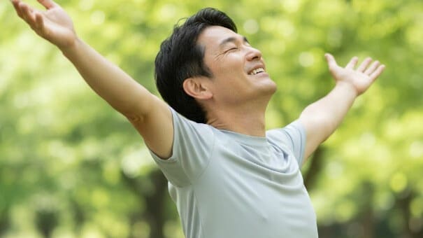 脇腹の痛みが消え、元気に深呼吸をする日本人男性。