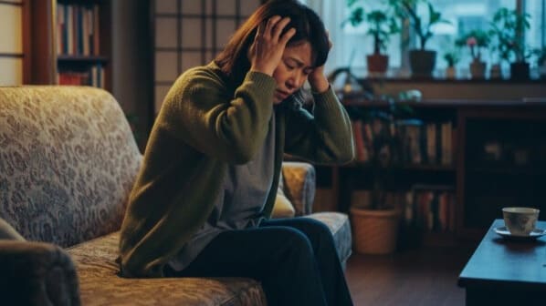 大阪市で寒暖差疲労による頭痛とダルさに悩む女性の様子