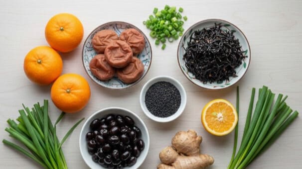 東洋医学で推奨される2月の食材、黒豆、黒ごま、梅干し、柑橘類、生姜が並ぶ様子